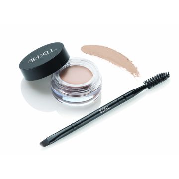 Uncapped container of Ardell Brow Pomade alongside brush/spoolie tool with pomade swatched onto background to show color